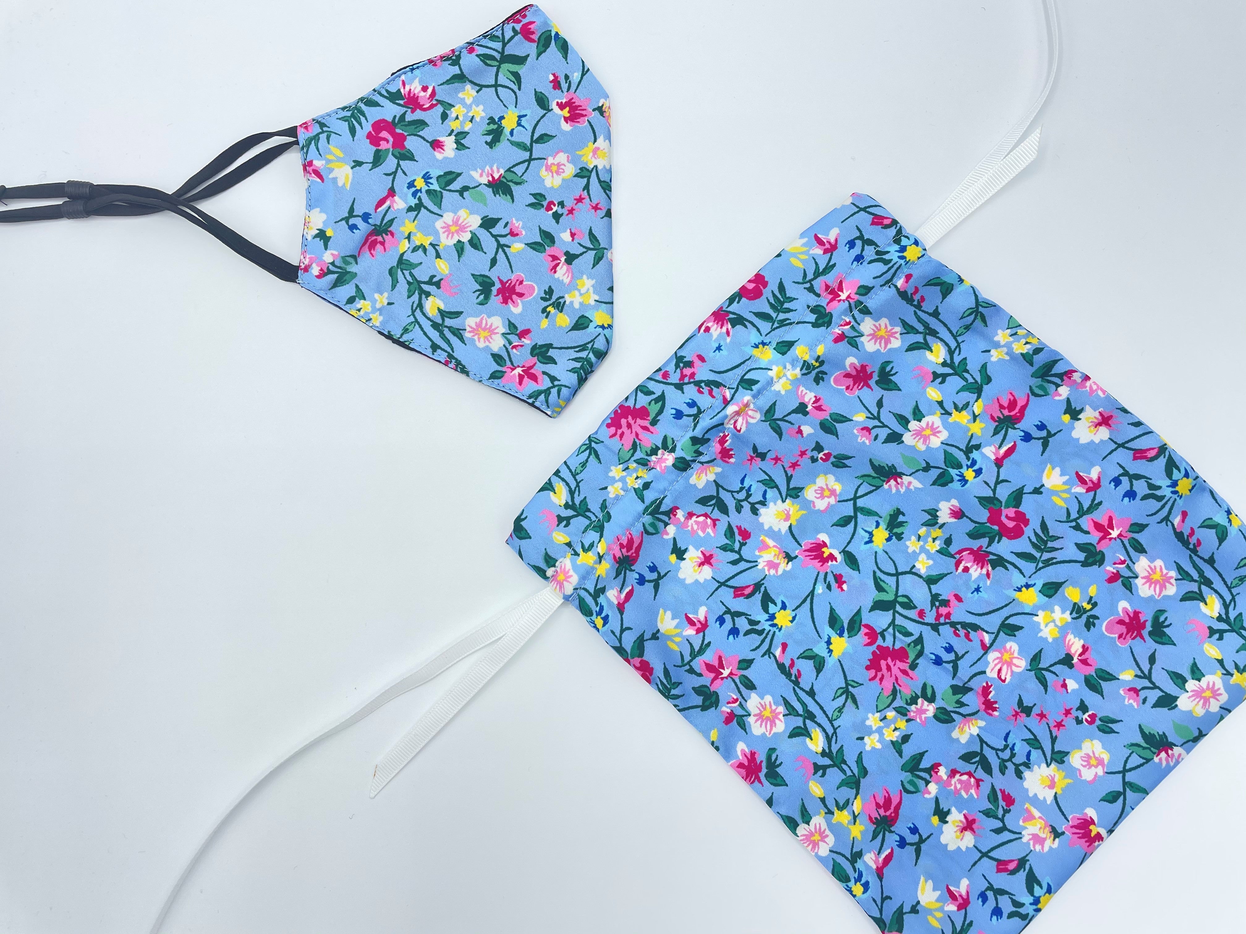 Blue floral face covering with adjustable straps, nose wire and matching floral carry bag